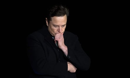 Musk fotografiado contra un fondo negro, barbilla en mano, mirando hacia abajo