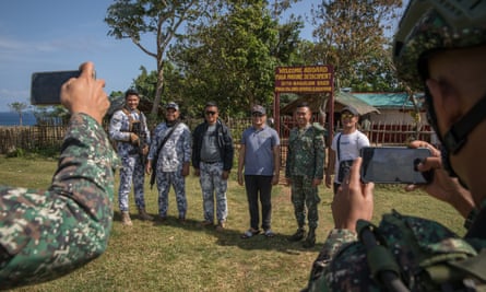 Los infantes de marina de la Armada de Filipinas y el personal de la Guardia Costera toman fotos de recuerdo durante una visita a la isla de Fuga
