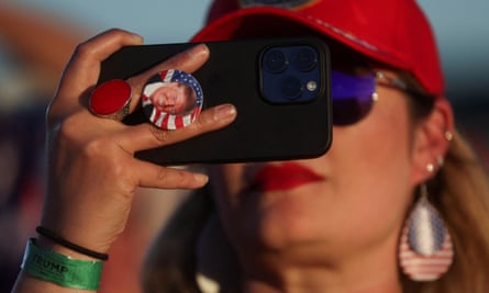 Una partidaria del expresidente estadounidense Donald Trump usa su teléfono durante su primer mitin de campaña