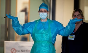 Un trabajador del Servicio Nacional de Salud Británico (NHS) usa equipo de protección personal (PPE) fuera del Hospital de la Universidad de Aintree en Liverpool