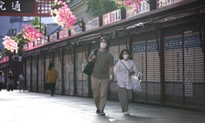 Personas con máscaras caminan por una calle de Asakusa, Tokio, Japón, 24 de mayo de 2020.