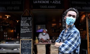 Un barman espera a los clientes detrás de un mostrador improvisado que bordea la acera en París