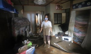 Residente local limpia la casa afectada por las inundaciones en Hitoyoshi, Prefectura de Kumamoto