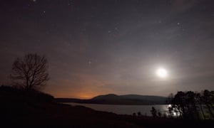 Cielos despejados por la noche sobre Clatteringshaws Loch, Galloway Forest Park, Dumfries y Galloway, Escocia.