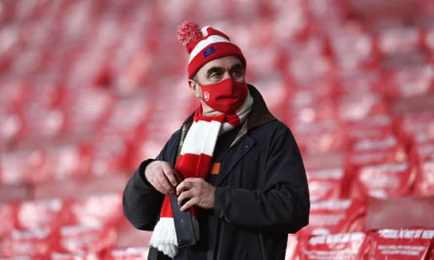 Un aficionado del Arsenal lleva una máscara protectora.