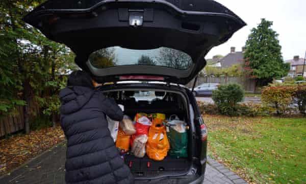 Un voluntario carga paquetes de comida en un automóvil en Londres en octubre de 2020