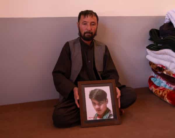 Abdul Rahim, de Daykundi en Afganistán, sostiene una foto de su hijo Nasim, de 22 años, otra víctima de la masacre de Mach.