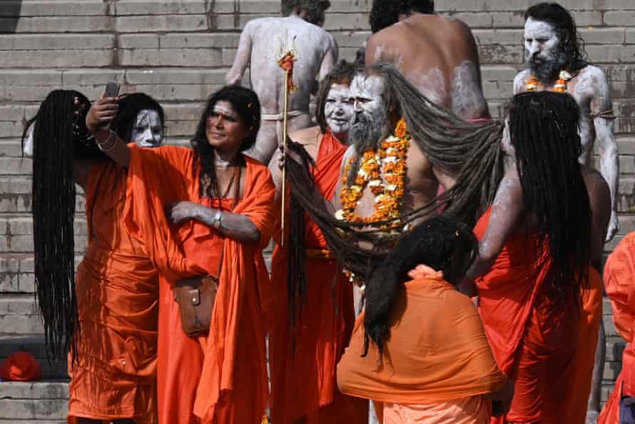 Naga sadhus (hombres y mujeres santos hindúes) toman fotos después de darse un chapuzón en las aguas del Ganges durante el Kumbh Mela en Haridwar.