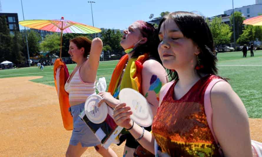 Frances Wilson, Claire Kilga y Raven Seydlitz participan en el calor abrasador en la marcha del orgullo por el Capitolio de Seattle el sábado.