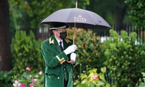 Un miembro del personal se protege bajo un paraguas durante el cuarto día de Royal Ascot.