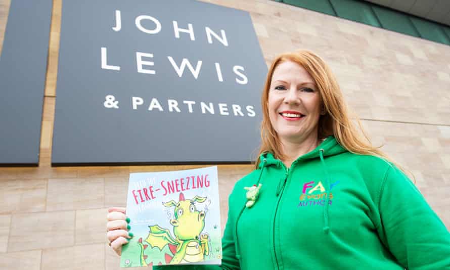 Fay Evans frente a una sucursal de John Lewis con su libro Fred the Fire-Sneezing Dragon