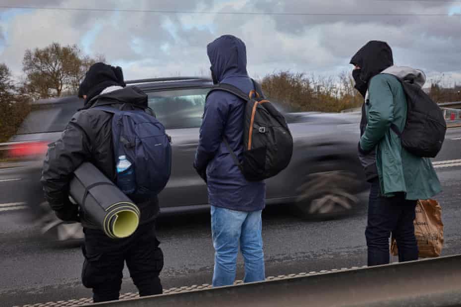 La gente espera al lado de la carretera cerca de Loon-Plage