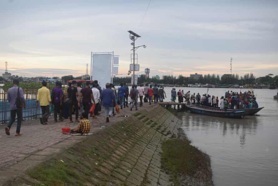 Los trabajadores de Mongla se alinean para hacer el viaje de regreso a través del agua en bote.