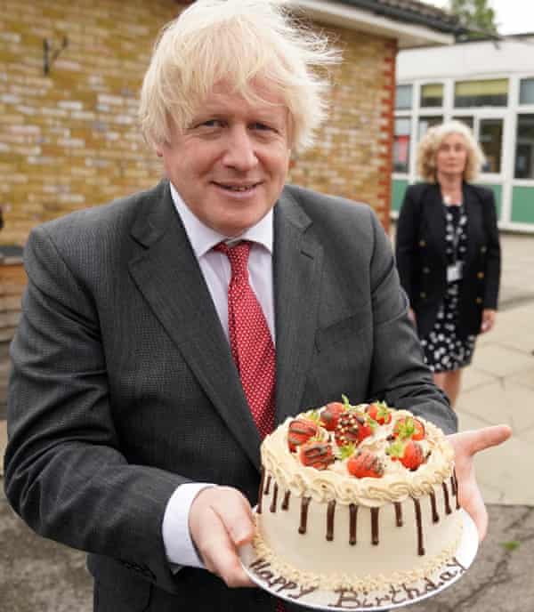 Boris Johnson sosteniendo un pastel de cumpleaños 