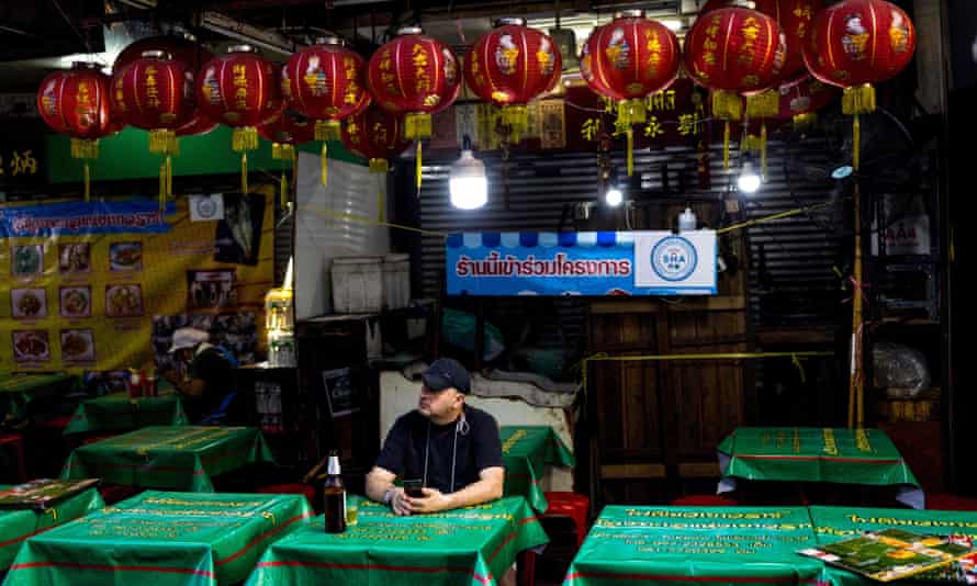 Un hombre bebe una cerveza en un bar del barrio chino de Bangkok.  Los bares y el sector turístico de la ciudad han sufrido mucho durante la pandemia. 