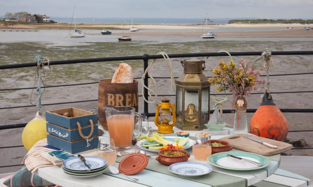 Una mesa para cenar en un barco, con vistas a un pequeño puerto, la marea está baja