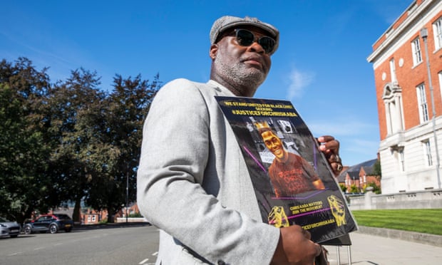 Un hombre sostiene una foto de Chris Kaba.