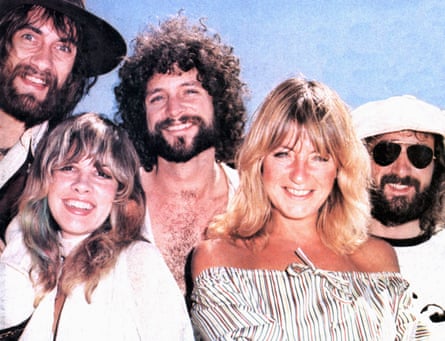 De izquierda a derecha: Mick Fleetwood, Stevie Nicks, Lindsey Buckingham, Christine McVie y John McVie, todos sonriendo ampliamente, alrededor de 1975.