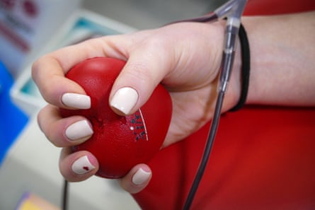 la mano sostiene una pelota de béisbol mientras dona sangre