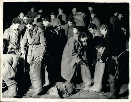 Los estudiantes de Kingston-on-Thames llenan sacos de arena a las 2 a. m. del 2 de febrero de 1953 cuando el río Támesis se desborda.